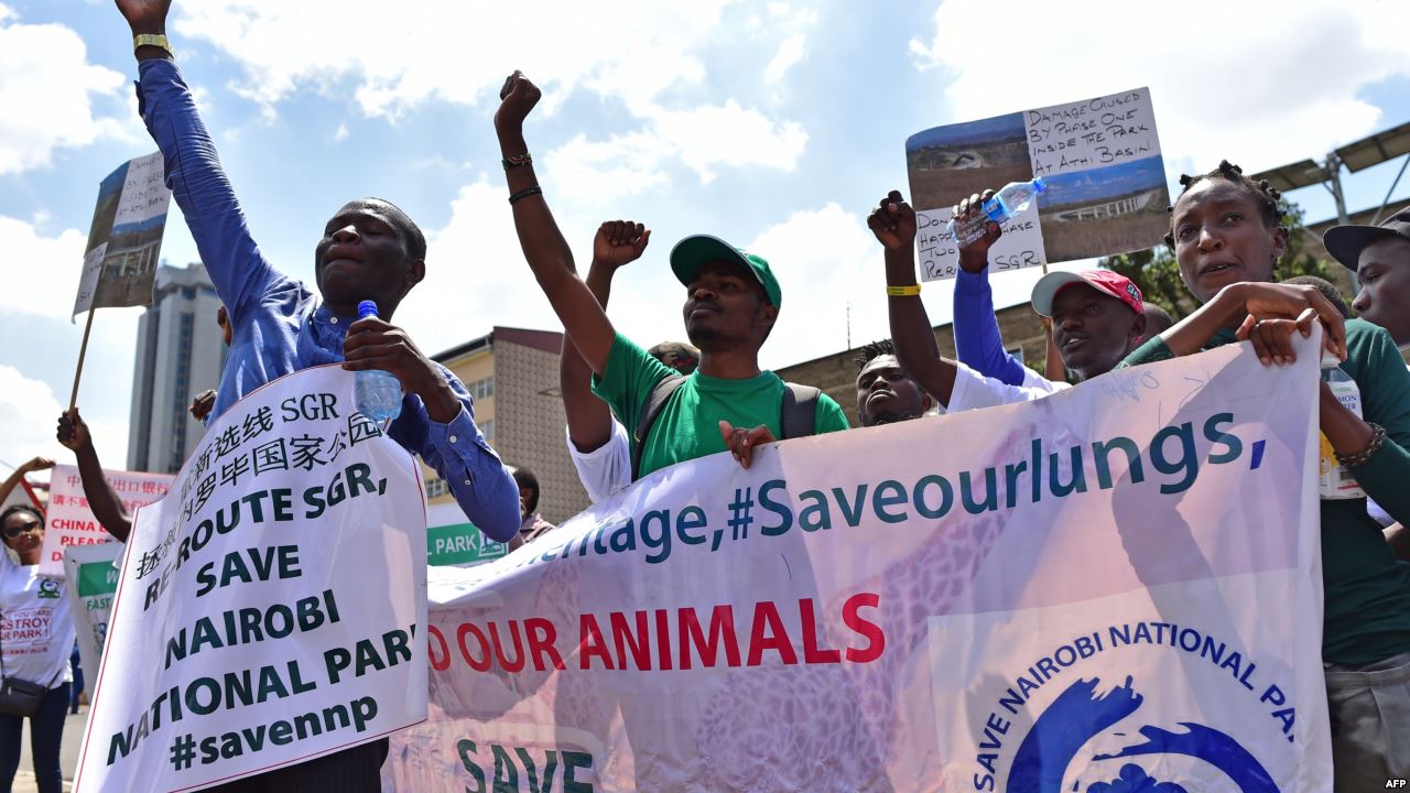 Environmental activists chant slogans as they carry placards and banners during a protest in Nairobi, Kenya, March 1, 2018, against a government decision to construct a standard-gauge railway line across the Nairobi National Park. 